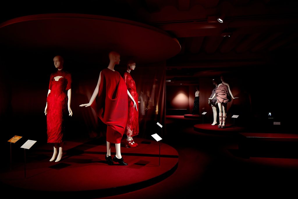 A trio of mannequins in red dresses with black shoes.