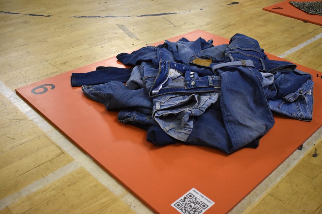 A pile of blue denim textile on an orange card.