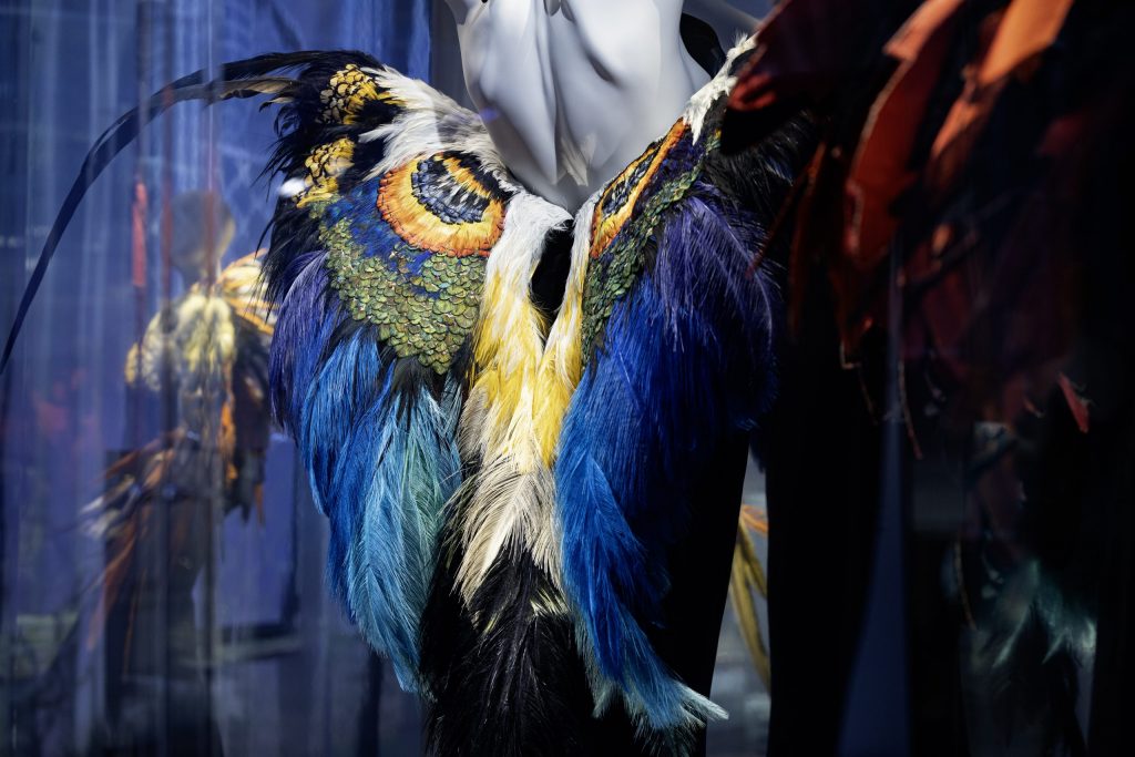 detail of dress made of blue and multi coloured feathers