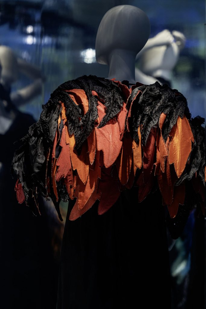 rear view mannequin with dress made of orange and black feathers