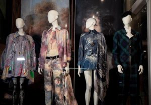 Four outfits displayed on mannequin in hues of blue, purple red and green tartan.