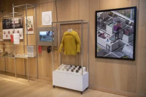 A yellow jumper on display inside a vitrine.