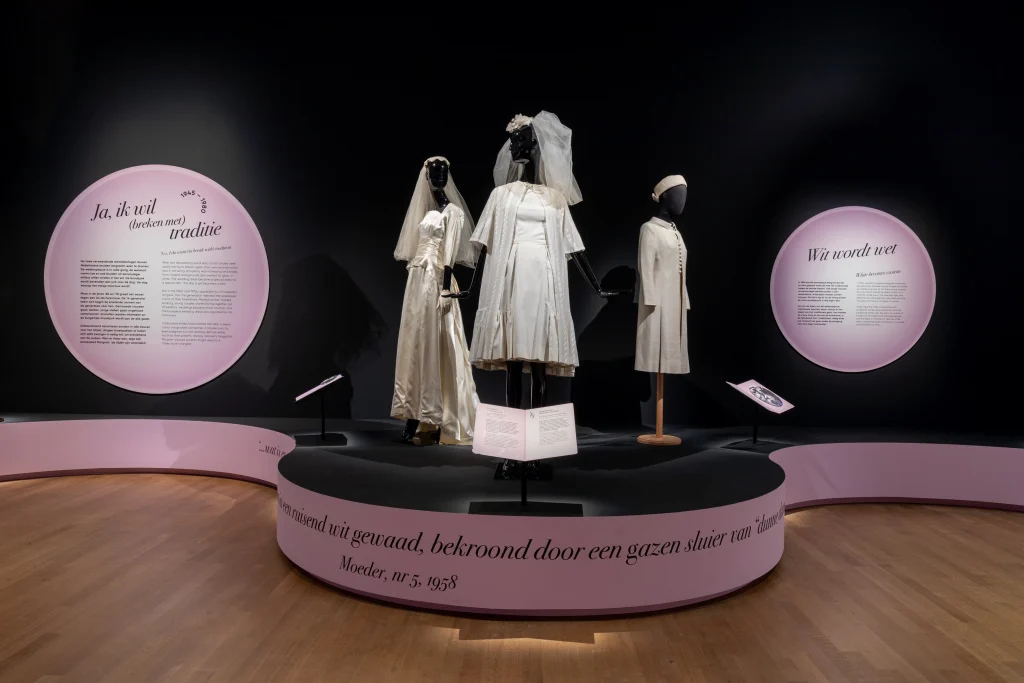 Three white wedding dresses with veils and a hat as an accessory.