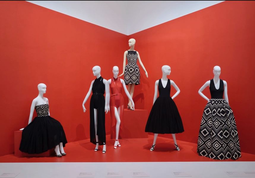 mannequins in a gallery with red backdrop