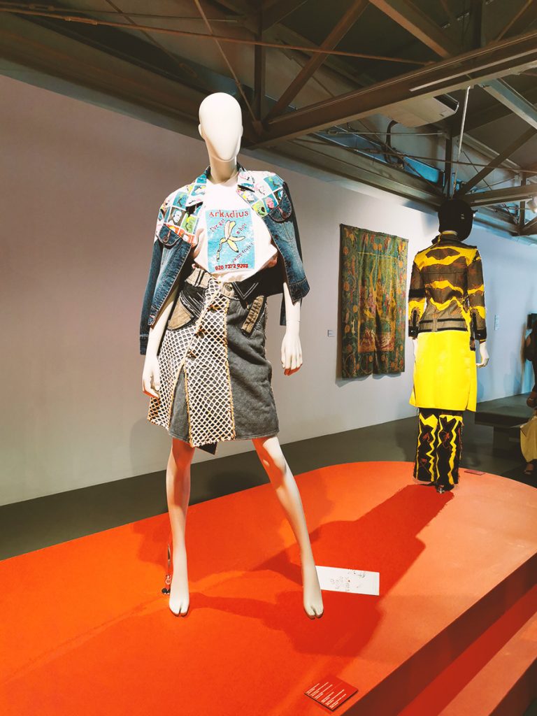 Two mannequins wearing two piece outfits in hues of blue, yellow, white and black.
