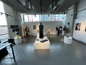 installation shot of mannequins on plinths in centre and around the gallery walls