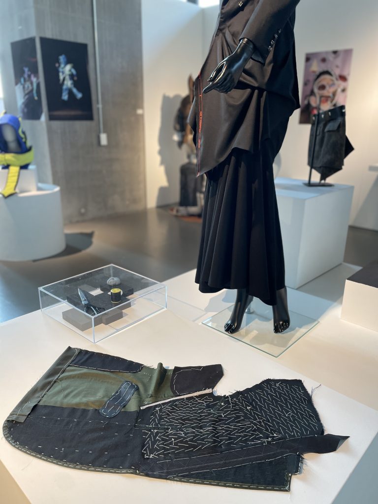 black attire on mannequin alongside a garment on floor