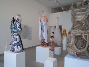 Dresses and outfits in hues of white, blue, yellow and orange.