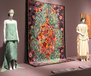 Two female dresses in hues of green and yellow.