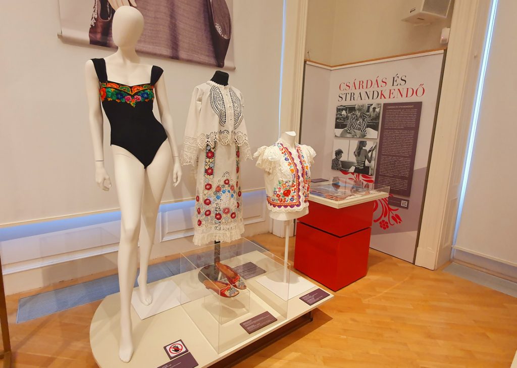 Summer clothing in hues of white, red and black with fringing.