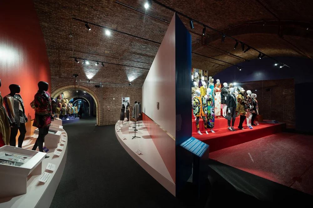 Exhibition display of mannequins shown from between two galleries