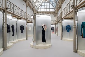 A collection of dresses and outfits in hues of black, pink and blue.