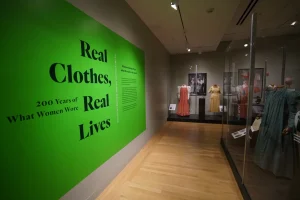 A collection of historical dress in hues of yellow, white and pink.
