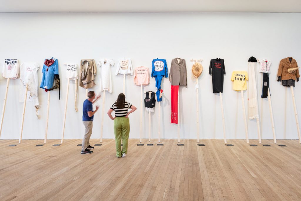 A collection of clothing in hues of green, yellow, red, white, blue and black.