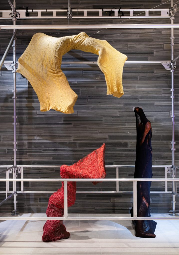 Clothing as shapes in hues of yellow, red and black.