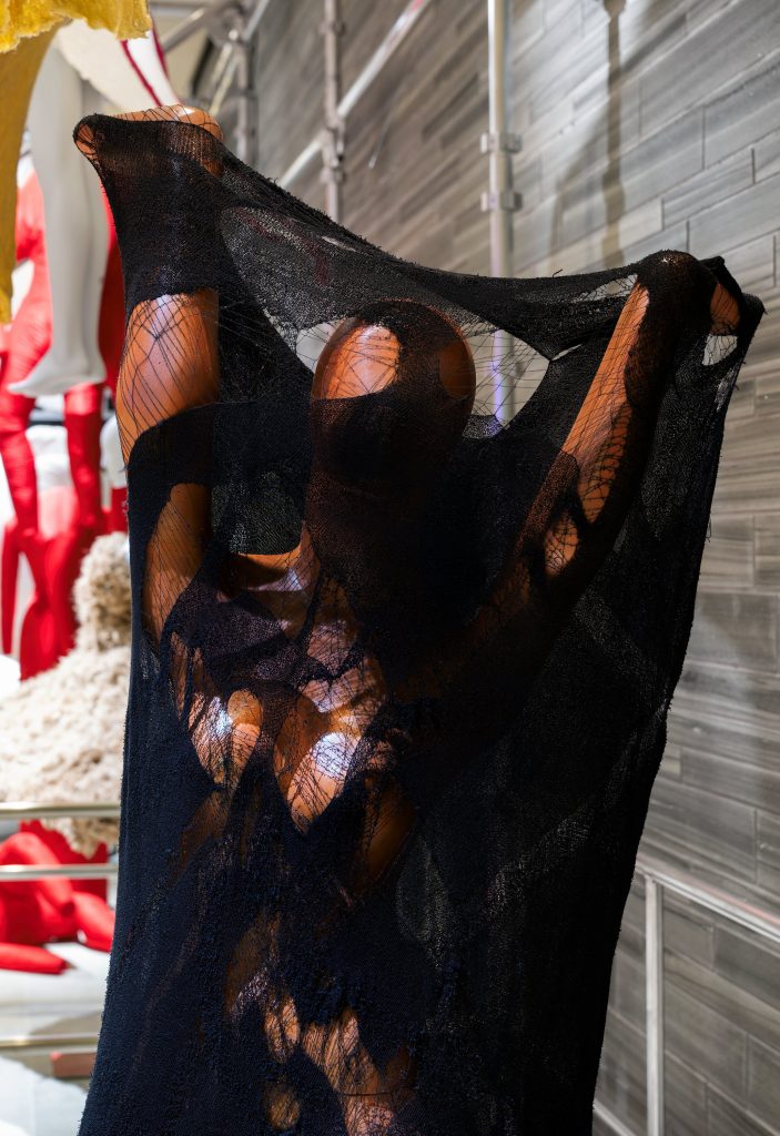 A mannequin wearing a lace black garment.
