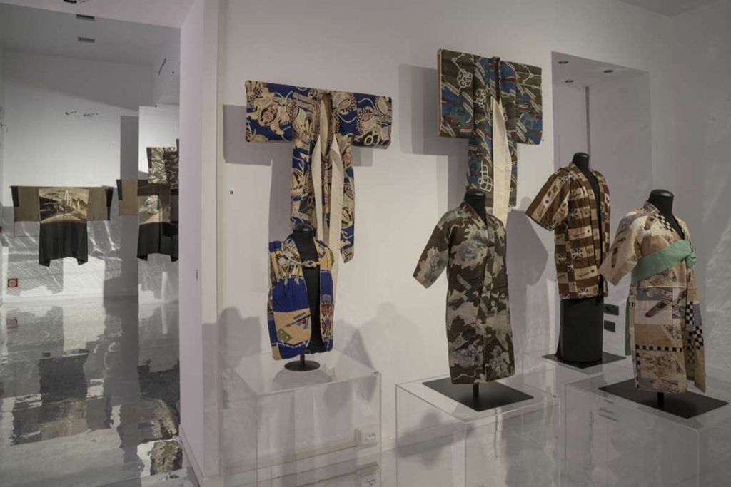 Four kimonos in differing patterns in hues of blue, grey, yellow and brown.