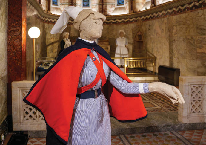 A mannequin wearing a historical nursing uniform in hues of blue, white, black and red.
