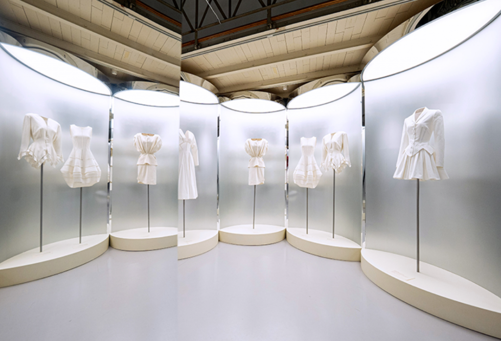 White outfits on display, in styles of midi and full length.
