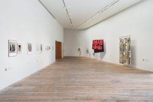 Textile on display in hues of black, red, green and white.
