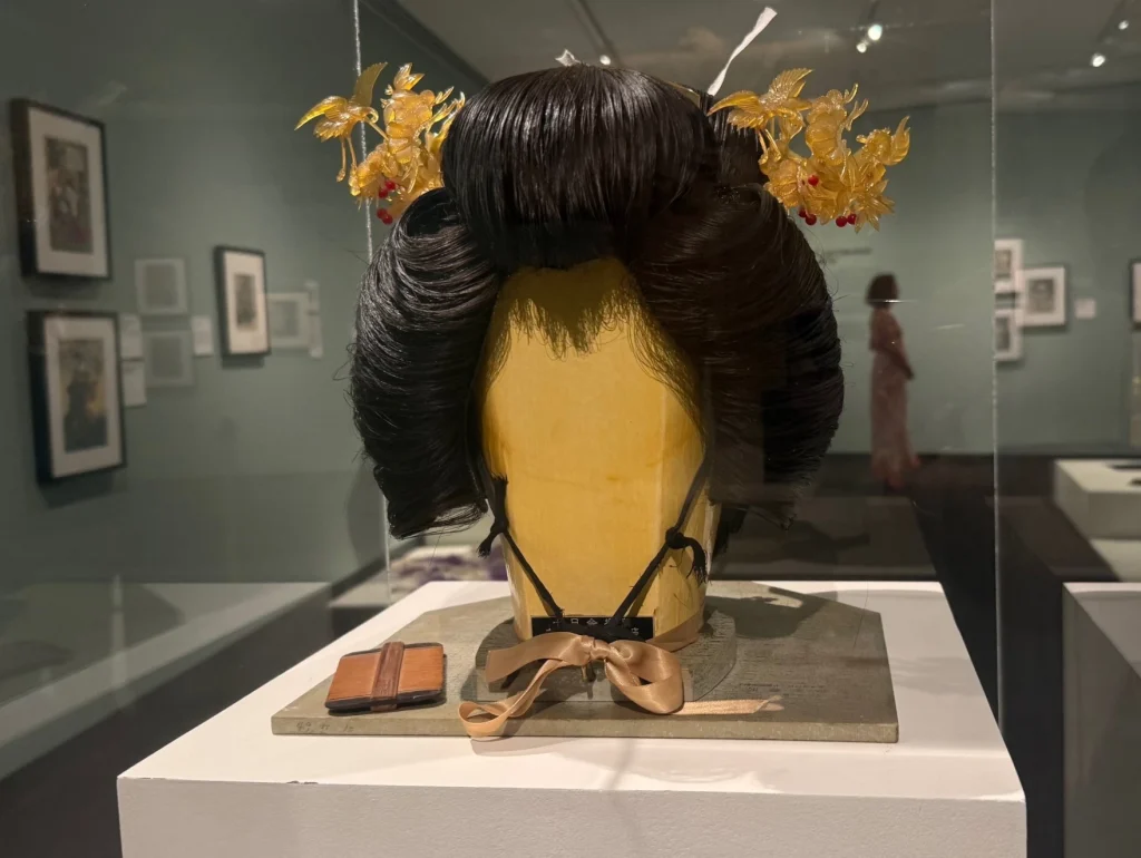 A short black wig with gold floral accessories placed either side.