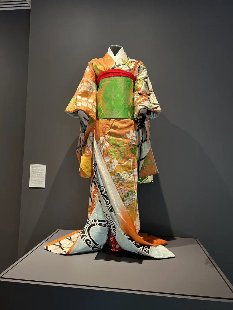 An orange, red and green kimono, with wide sleeves.