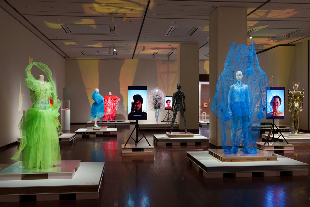 Mannequins wearing clothing in bold colours of green blue and red.