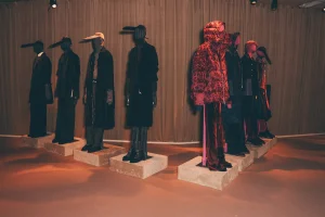 Mannequins wearing black and red coats and trousers.